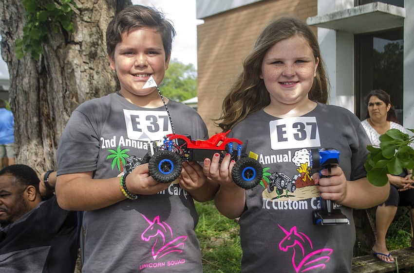 Jacob Gardner and Lila Kemper pose with their remote control car. Their team was the first to make it throw the blind course.