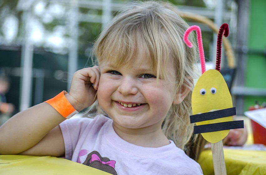 Violet Robbins shows off the bee she made at the craft tent.
