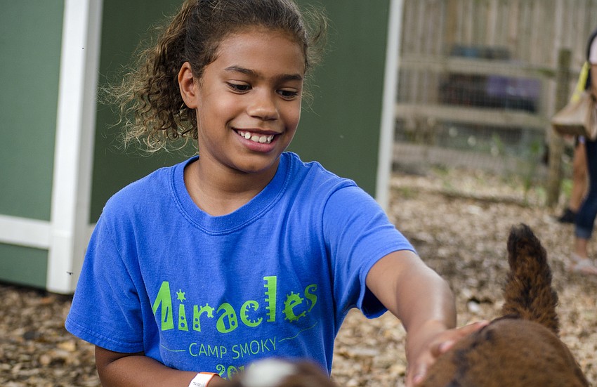 Addison McCoig pets a goat.