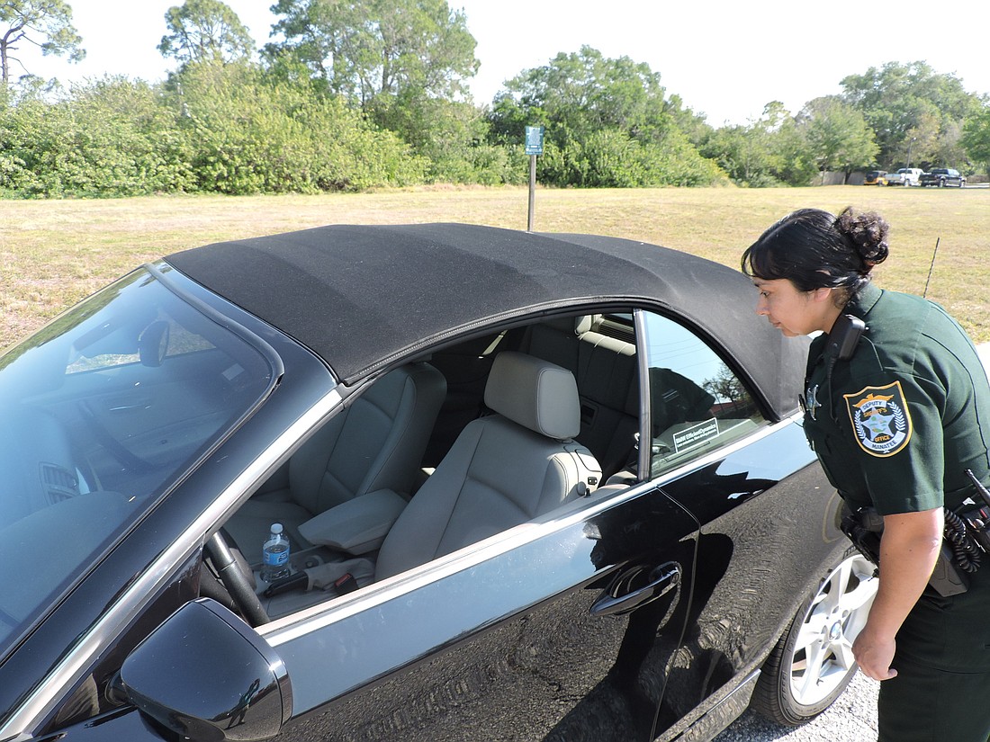 Leticia Leon, a deputy with the Manatee County Sheriff&#39; s Office, checks out a car where the owner left the door unlocked and the window down. Leon patrols Lakewood Ranch area neighborhoods.