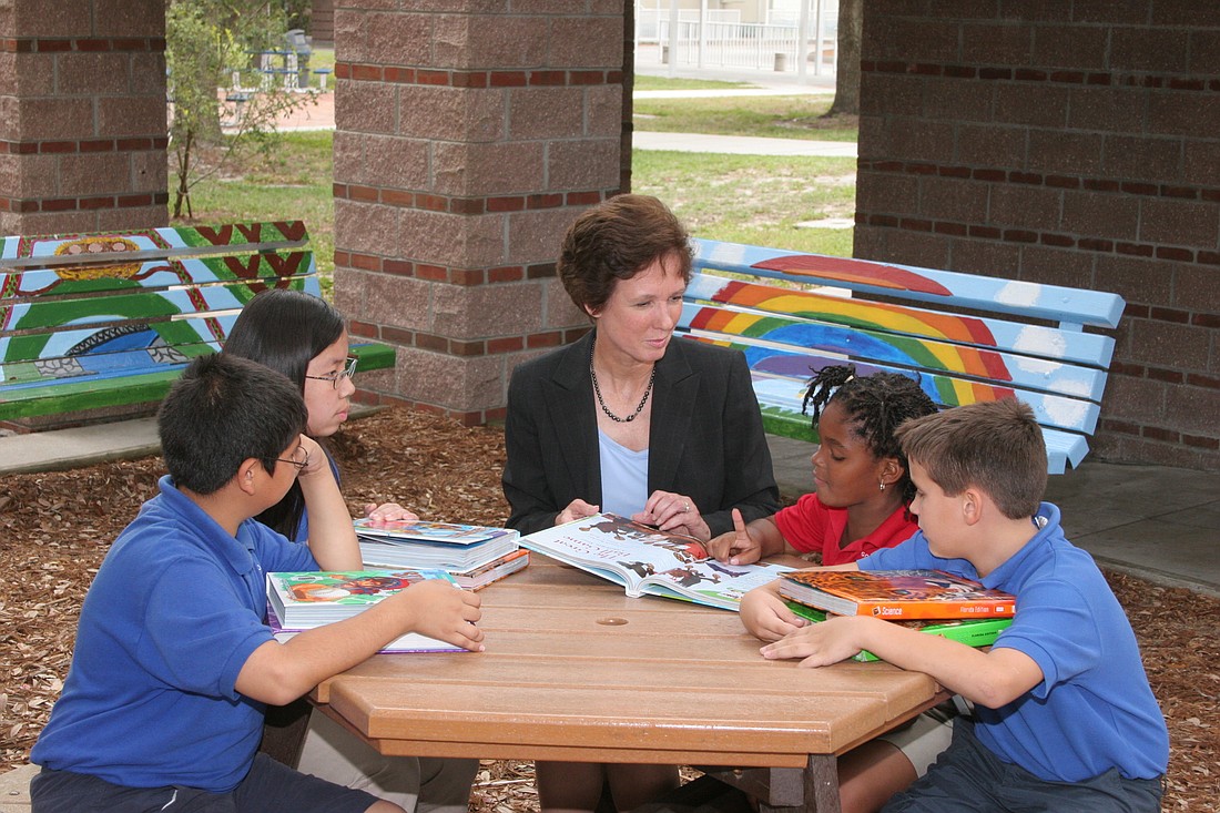 Former Superintendent Lori White sits with students at Gocio Elementary School. White retired from her position in February 2017.