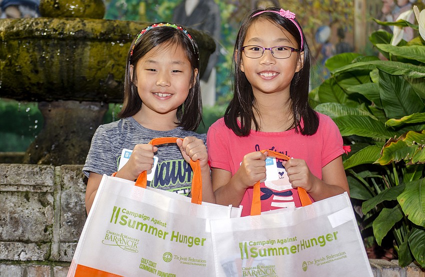 Allison and Anna Kim pose with their Campaign Against Summer Hunger bags.