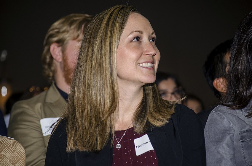 Heather Gamwell smiles while watching a video telling the stories of female ground breakers in the field of law featuring Teen Court volunteers.