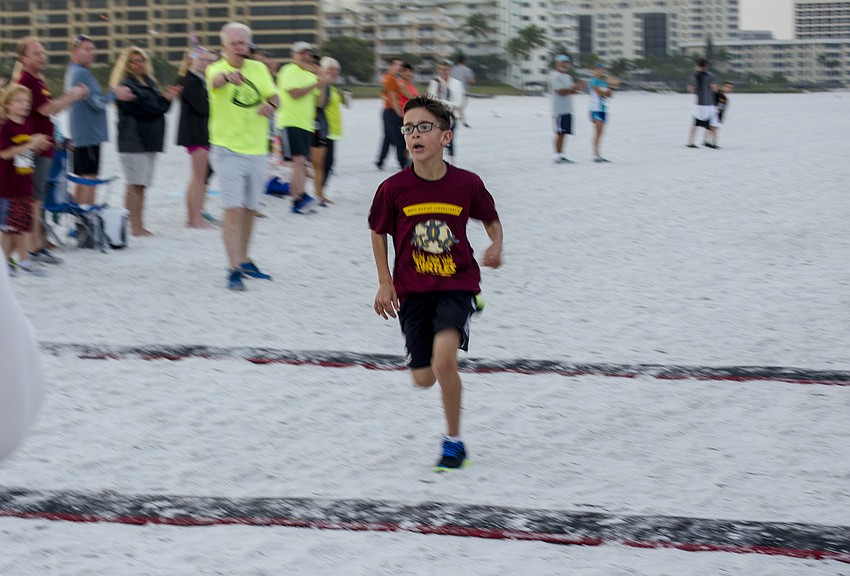 Luke Helmuth finishes the one-mile children' s fun run.