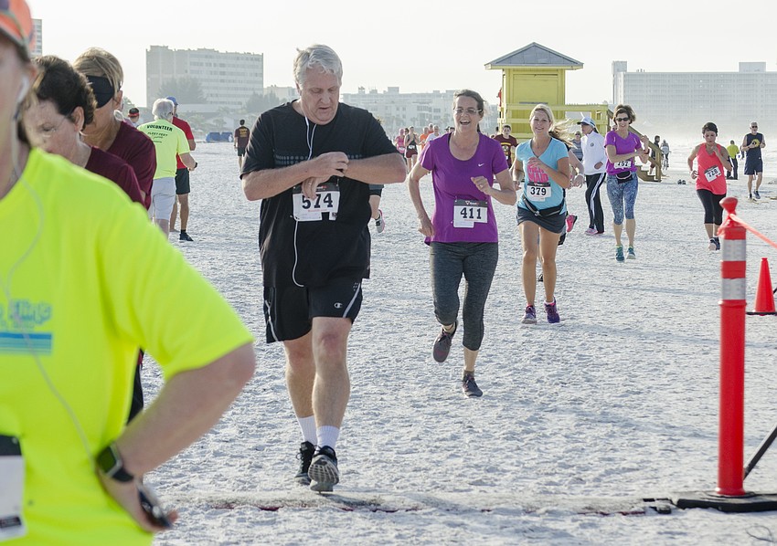 Runners cross the finish line of the 31st annual Run for the Turtles.