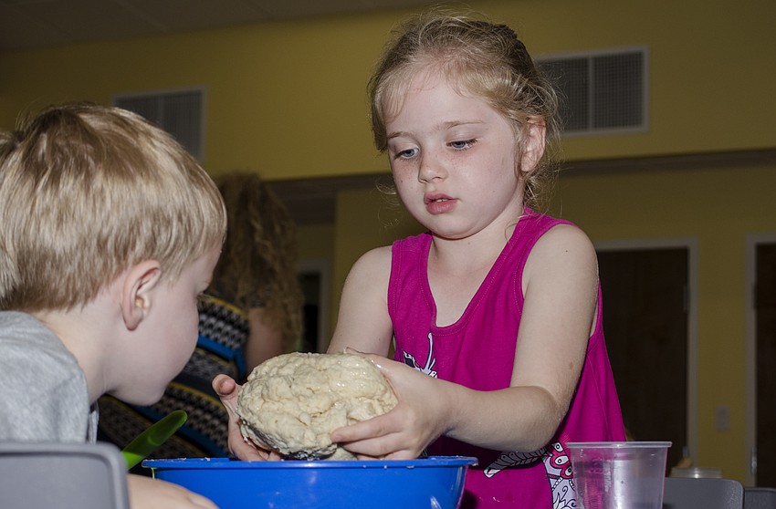 Alana Duffy kneads her family' s challah dough at the challah workshop at Temple Emanu-El.