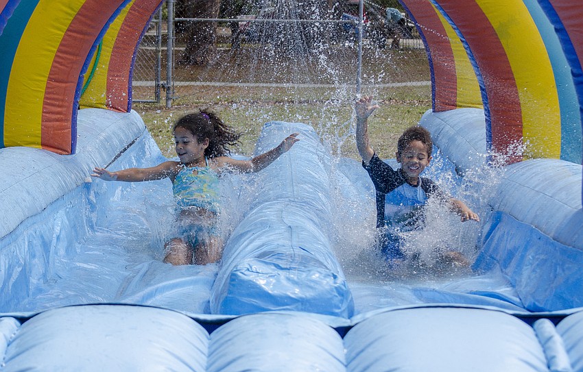 Samyiah and Micah McGee play in the inflatable slip and slide at the Arlington Park Spring Splash.