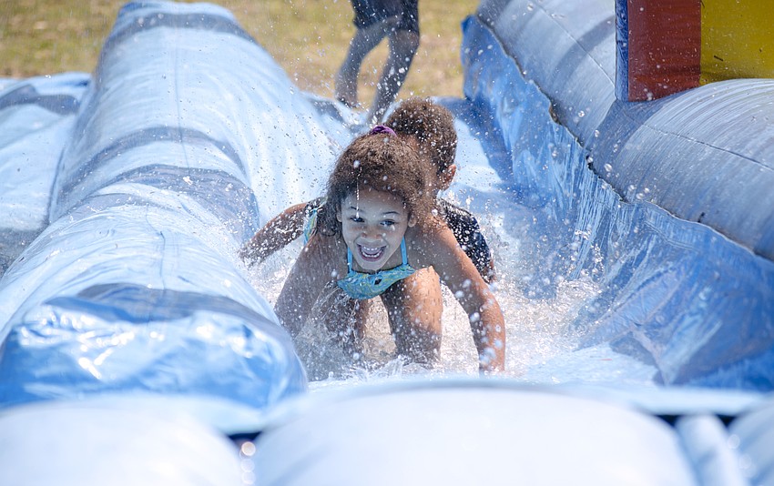 Samyiah McGee plays in the inflatable slip and slide at the Arlington Park Spring Splash.