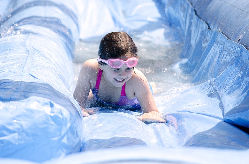 Ashleigh Canfield plays in the inflatable slip and slide at the Arlington Park Spring Splash.