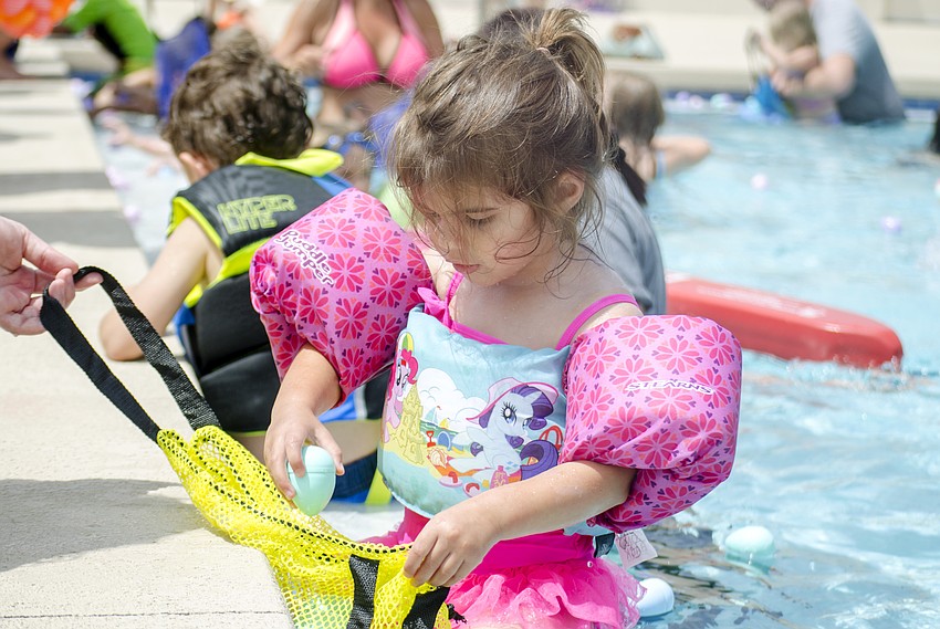 Sofia Jackson collects eggs during the Arlington Park Spring Splash.