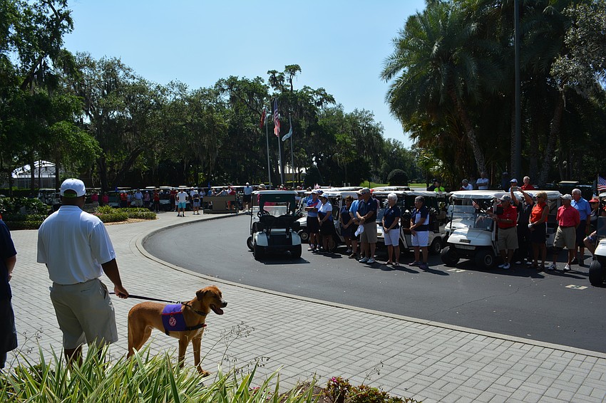 Golfers pull up their carts for the opening ceremony.