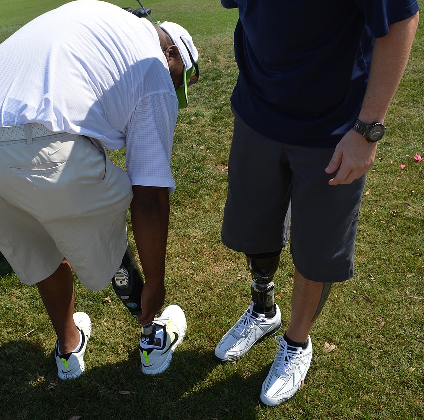 Army Staff Sgt. Christopher Gordon discusses prosthetic devices with Capt. Bobby Withers before the tournament.