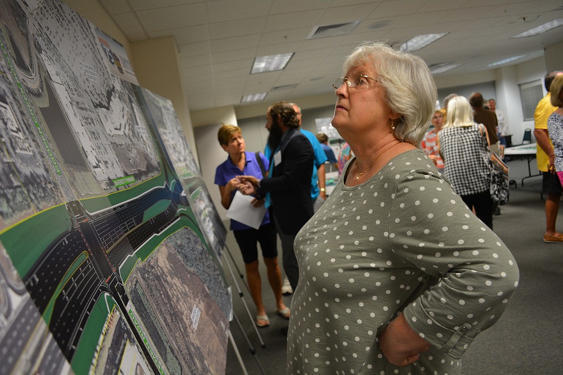 Linda Barnes, of Sarasota,  scopes out a large-scale map of the new configuration during an April 4 public meeting on the project.
