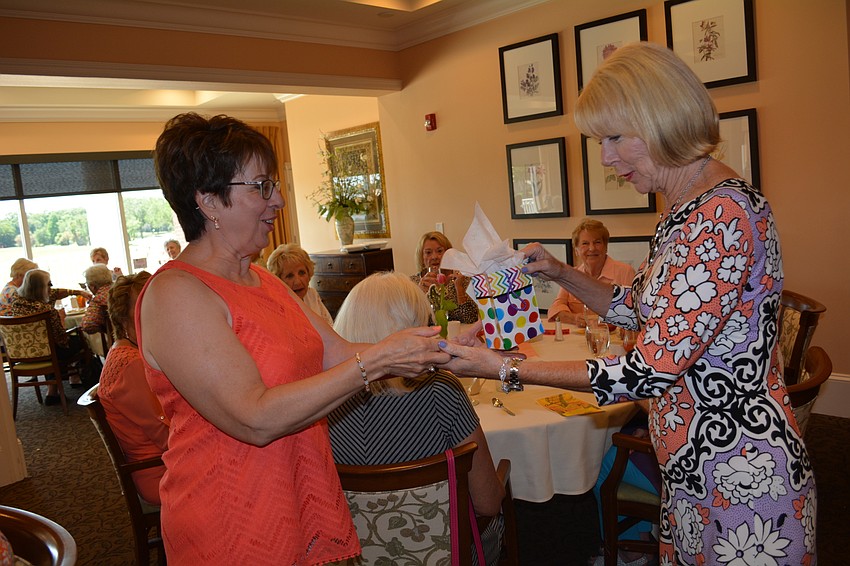 Barbara Raper accepts her prize for winning the raffle, a gift card to Anthony' s, from Barbara Agnello.