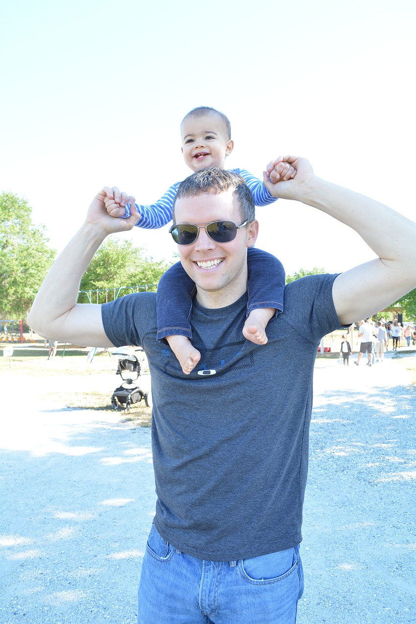 East County' s 11-month-old Caden Shane gets a birds-eye view from his father, Tom Shane, of his sister, Karina, 3, as she readies for the egg hunt.