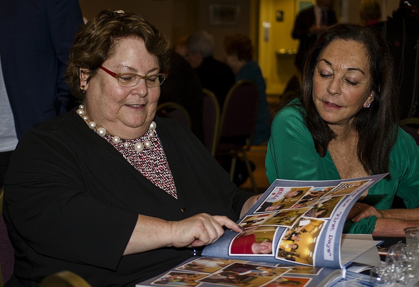 Sue Huntting looks at photos in the commemorative photo album she was given to recognize her nine years of service as Religious School director.