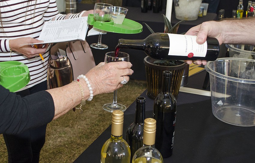 A Whitehall Lane Winery employee pours Whitehall Lane Cabernet from Napa Valley during the Florida Winefest & Auction Grand Tasting, Brunch and Charity Auction on April 8 on the grounds of the Van Wezel Performing Arts Hall.