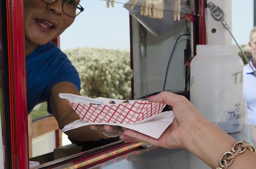 Judy VanHouten receives her order from BulGoGi Sarasota at Wine on the Water on April 9 on the grounds of Van Wezel Performing Arts Hall.
