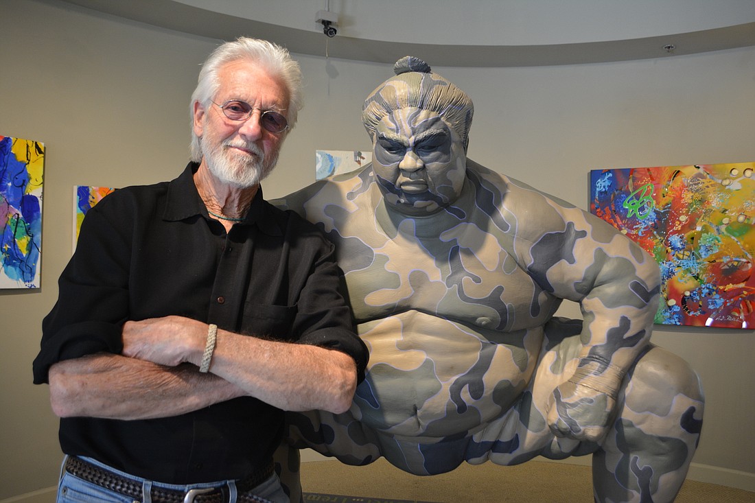 Sarasota artist Jack Dowd stands next to his sculpture "Camo Sumo" that is being offered for $15,000 during the Sarasota Visual Artists&#39;    "Open Studio Series" on Lakewood Main Street.