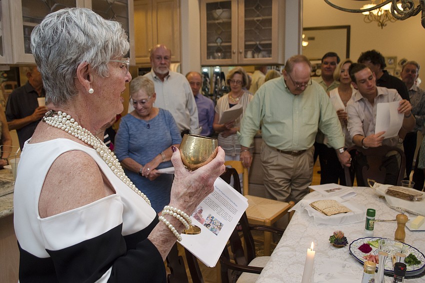 Susan Masters raises a cup for the prophet Miriam during the Passover seder at the Straff Passover Party on April 10 at the home of Roberta and Larry Straff.