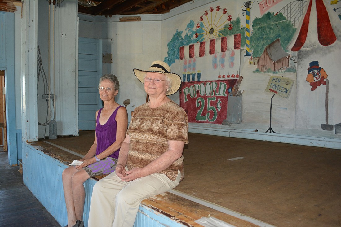 Bonnie Carlton and Marilyn Coker of the Myakka City Historical Society sit on the stage they hope will host community events.