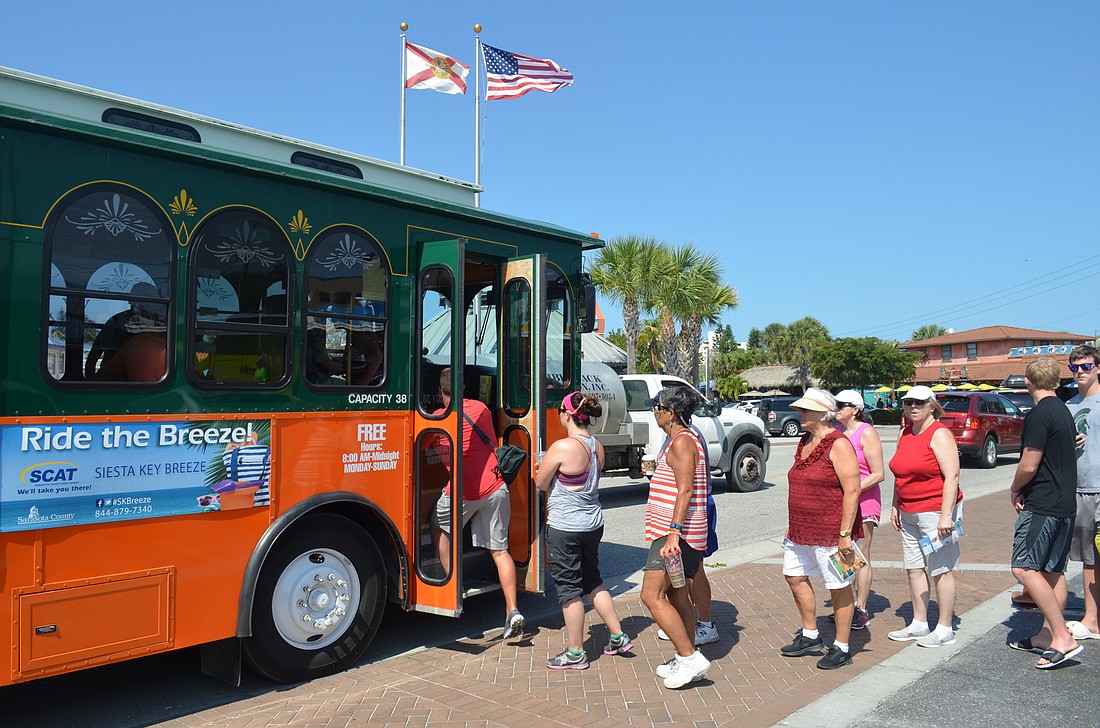 Riders get on the Siesta Key Breeze trolley service in Siesta Key Village. There have been more than 25,000 riders on the trolley in its first 15 days.
