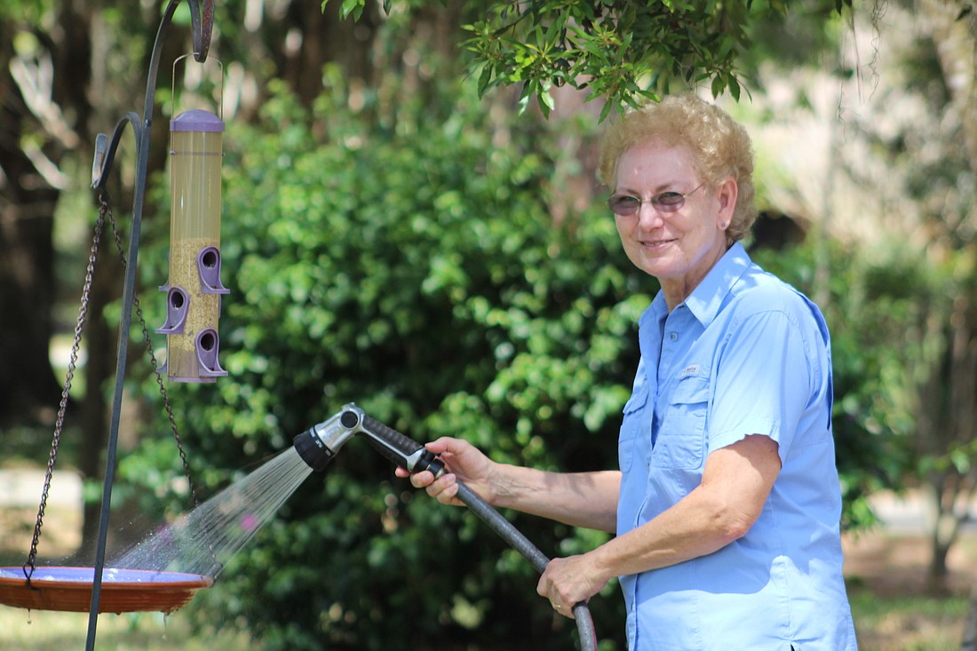 raden Woodsâ€™ Susan Darovec refills the bird bath in her front yard.