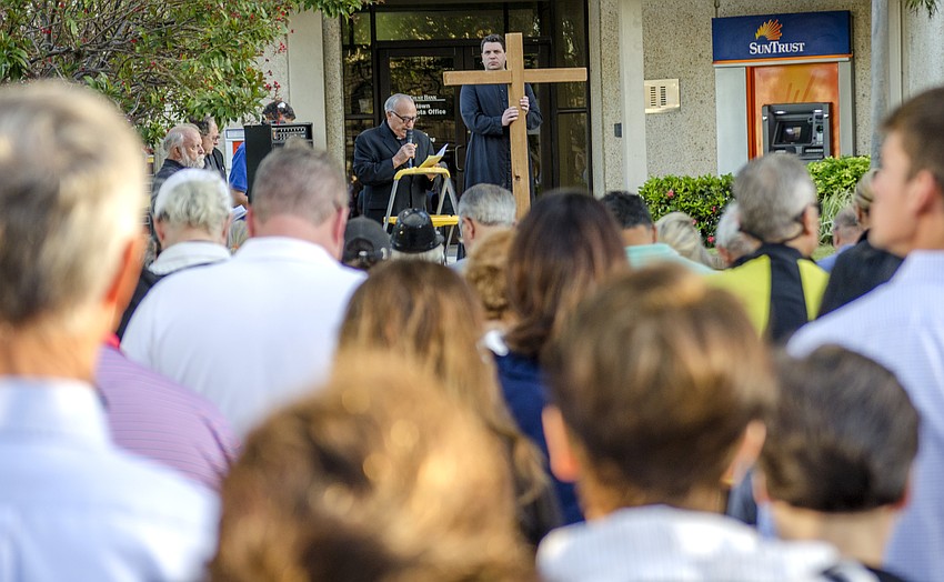 The crowd stopped in front of the SunTrust building to observe the fourth station of the cross.