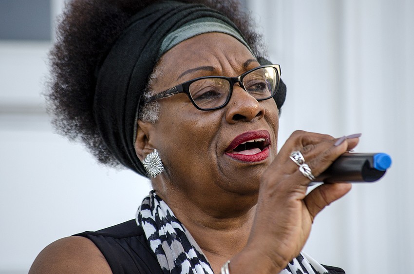 Shelia Atkins leads participants in song at the steps of FirstSarasota the Downtown Baptist Church.
