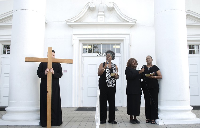 Chris Wood, Shelia Atkins, Bonnie Williams and Regina Jenkins stand in front of FirstSarasota the Downtown Baptist Church to recognize the sixth station of the cross.