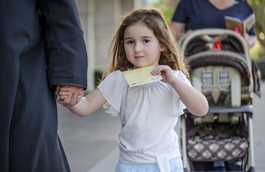 Lily Spaulding walks down Main Street during the Good Friday walk, which stopped at 14 locations to commemorate the 14 stations of the cross.