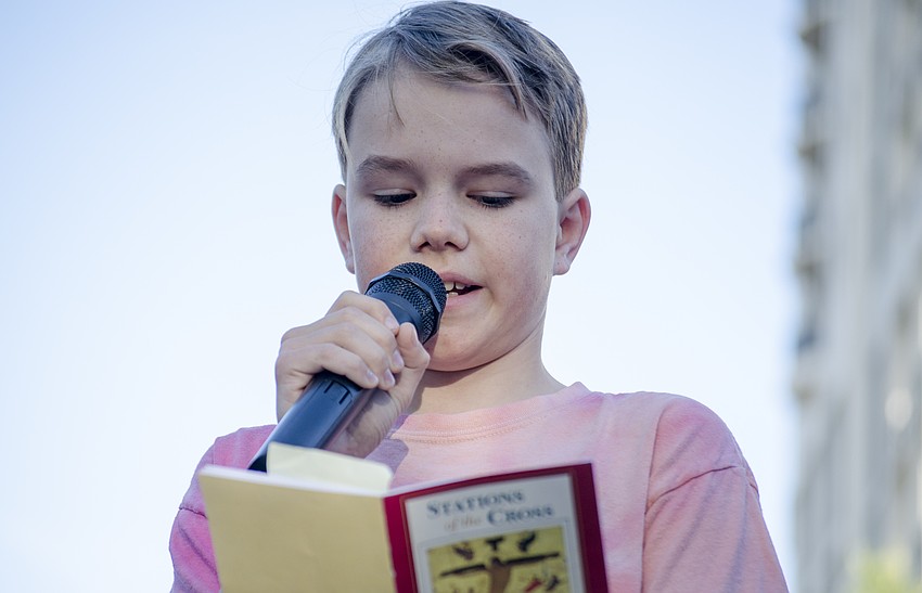 Ben Strom leads the crowd through the ninth station of the cross at the intersection of Main Street and Lemon Avenue.