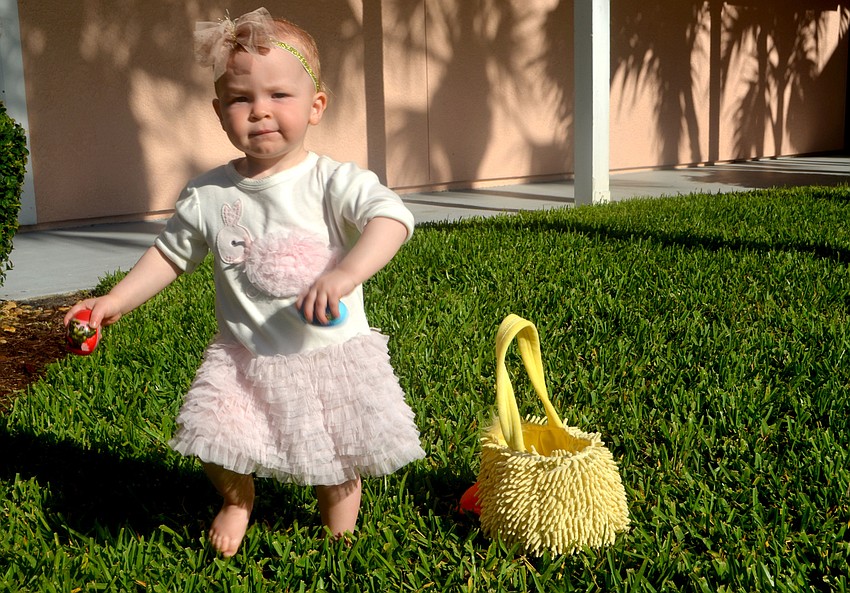 Samantha Simmons, 14 months, carries the eggs she found to her basket during Sand Cay’s Easter Egg Hunt.