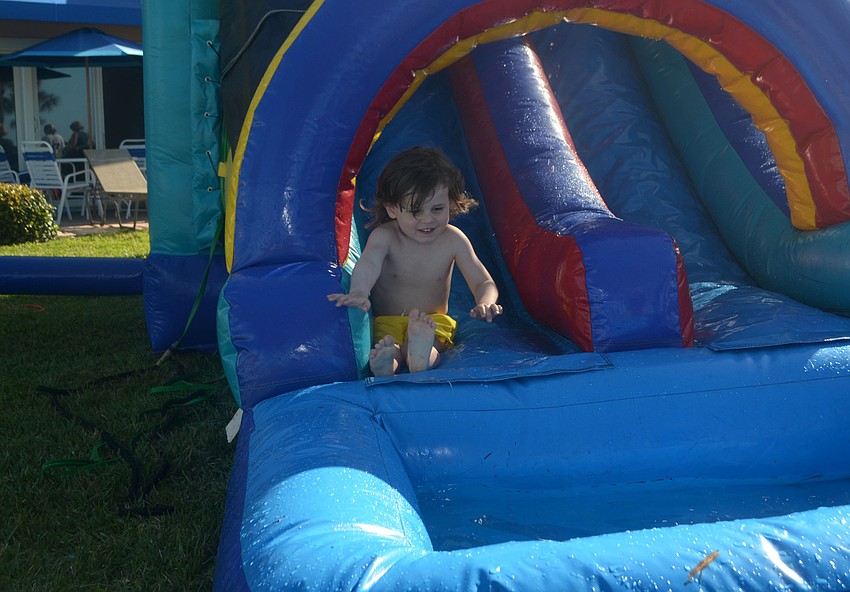 Mac Albring, 3, takes a turn on the inflatable waterslide during Sand Cay’s Easter Egg Hunt on April 14.
