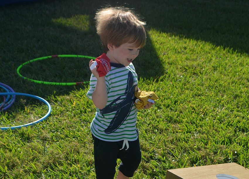 Tanner Haden picks up beanbags around the lawn of Sand Cay.