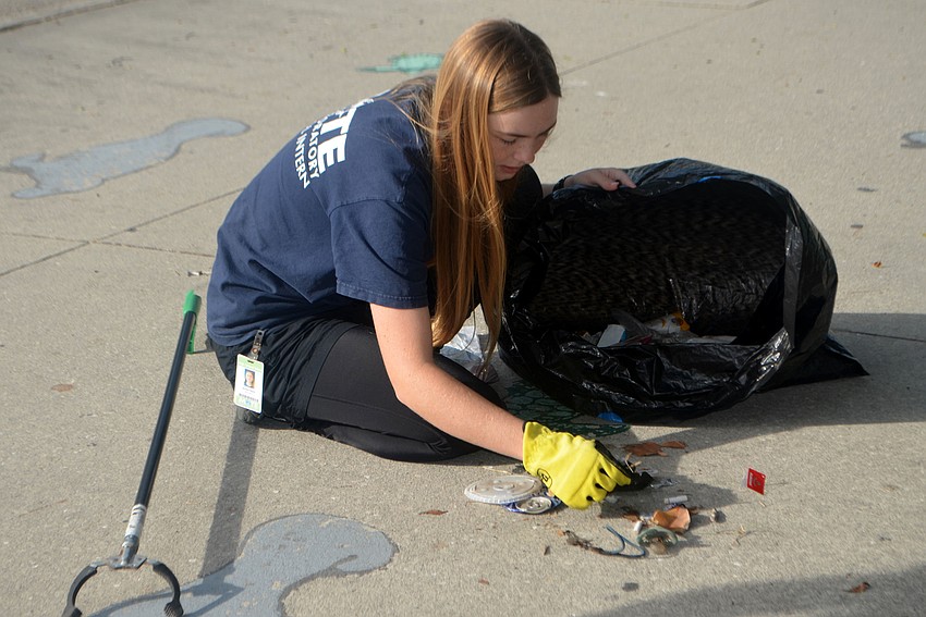 Brooke Welch sorts the trash her group found around Mote’s property.