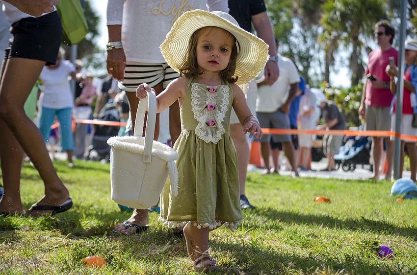 Lilliana Mileto collects eggs during the Siesta Key Easter Egg Hunt.