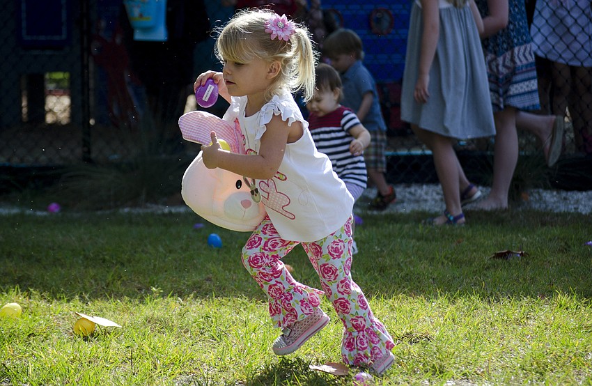 Rachel Wenk collects eggs during the Siesta Key Easter Egg Hunt.