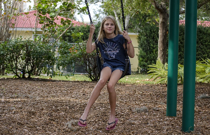 Sydney Andrews swings in Laurel Park during the neighborhood'     s Tunes in the Park event.