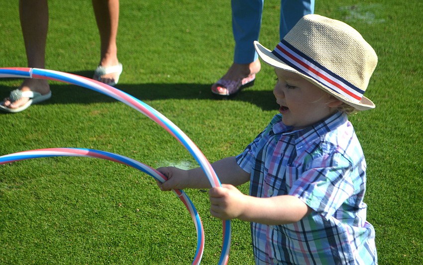 Blaze Antos, 1 ½, plays with hula hoops before the Longboat Key Club’s Easter egg hunt on April 16.