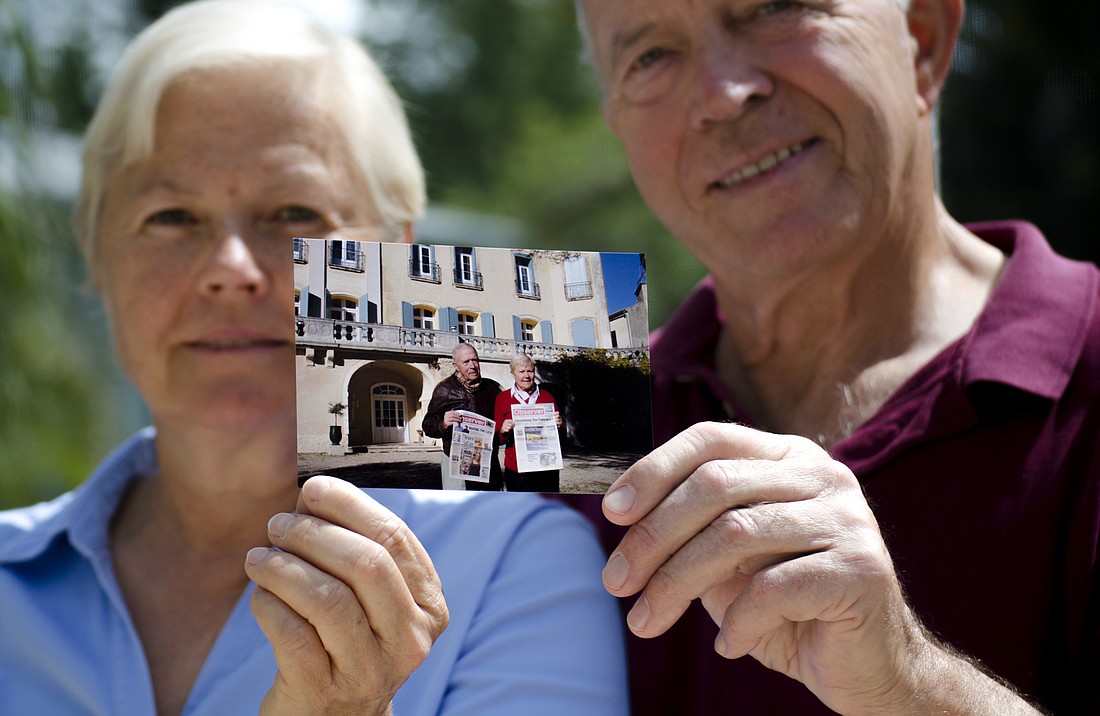 Martine and Pierre Filiatrault pose with a photo taken in front of their castle in Gaujac, France.