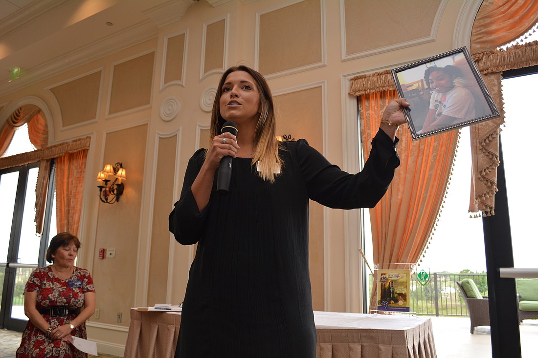 Childrens Dream Fund Marketing and Communications Director Amanda Griffin holds up a picture of a 9-year-old girl who will benefit from the Rotary grant. The girl, Kiya, will go to Give Kids the World.