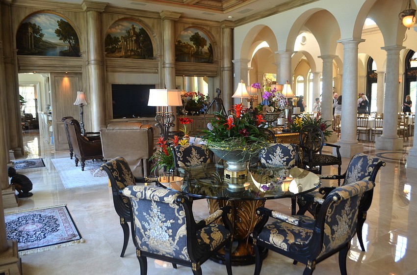 A living room off the front foyer boasts a bar, sitting area and table.