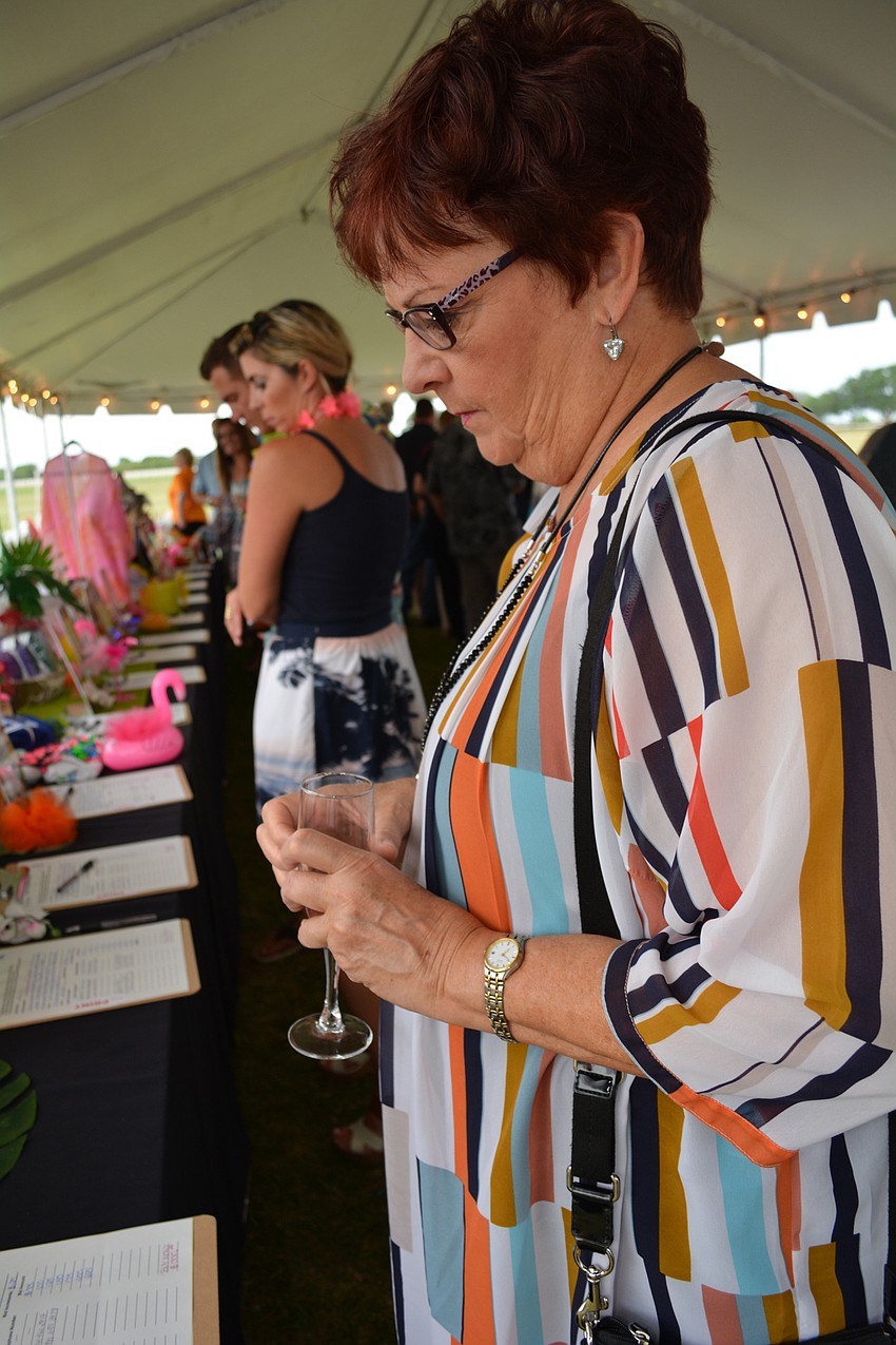 Palm Aire'   s Laurie Lawrence checks out the silent auction items.