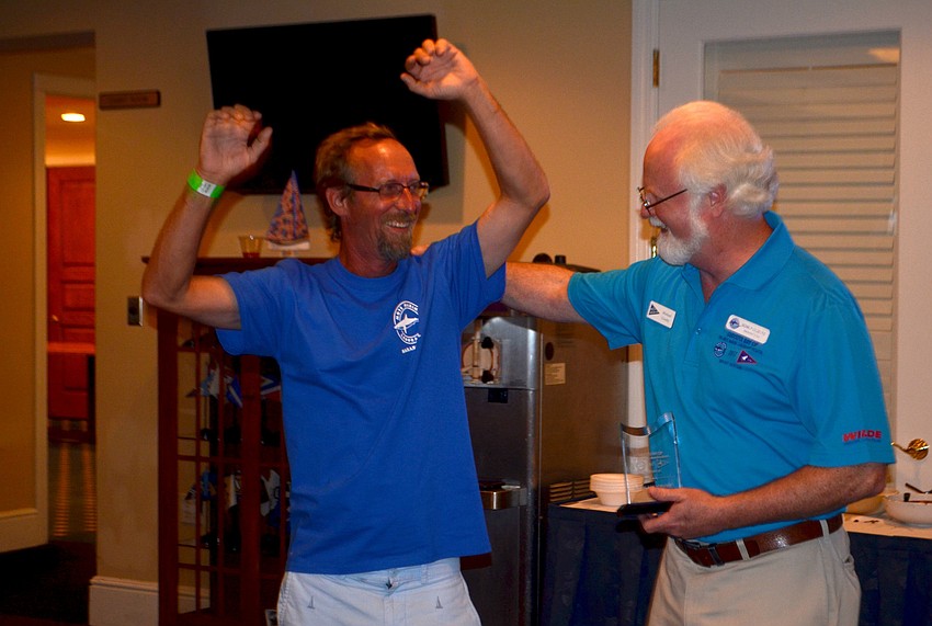 Mike Collins, a Mote staff member, accepts the award for third place in the cruiser division of the PHRF Course from Mote President and CEO Michael Crosby.