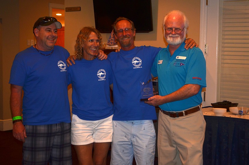 Rob Roche, Sue Forrest and Mike Collins accept the award for third place in the Cruiser division of the PHRF Course from Mote President and CEO Michael Crosby.