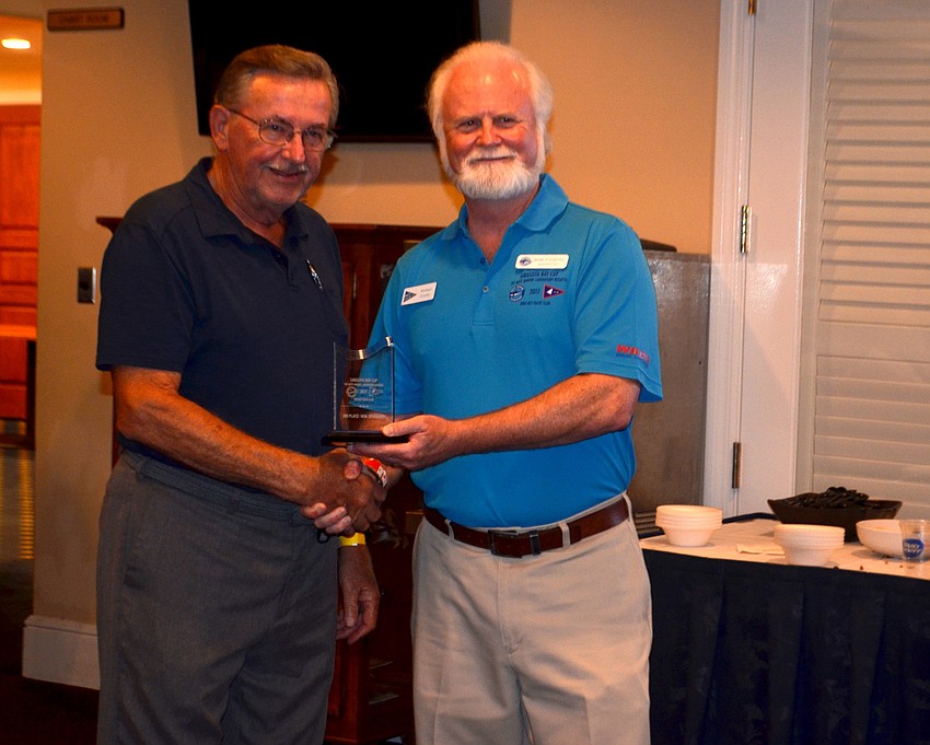 Rudolf Reinecke accepts the award for second place in the non-spinnaker division for the PHRF Course from Mote President and CEO Michael Crosby.