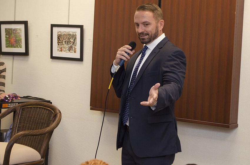 Tom Urfer points out that his son is in the crowd because of Take Our Daughters and Sons to Work Day while attending the Carolyn Michel lecture on April 27 at Designing Women Boutique.