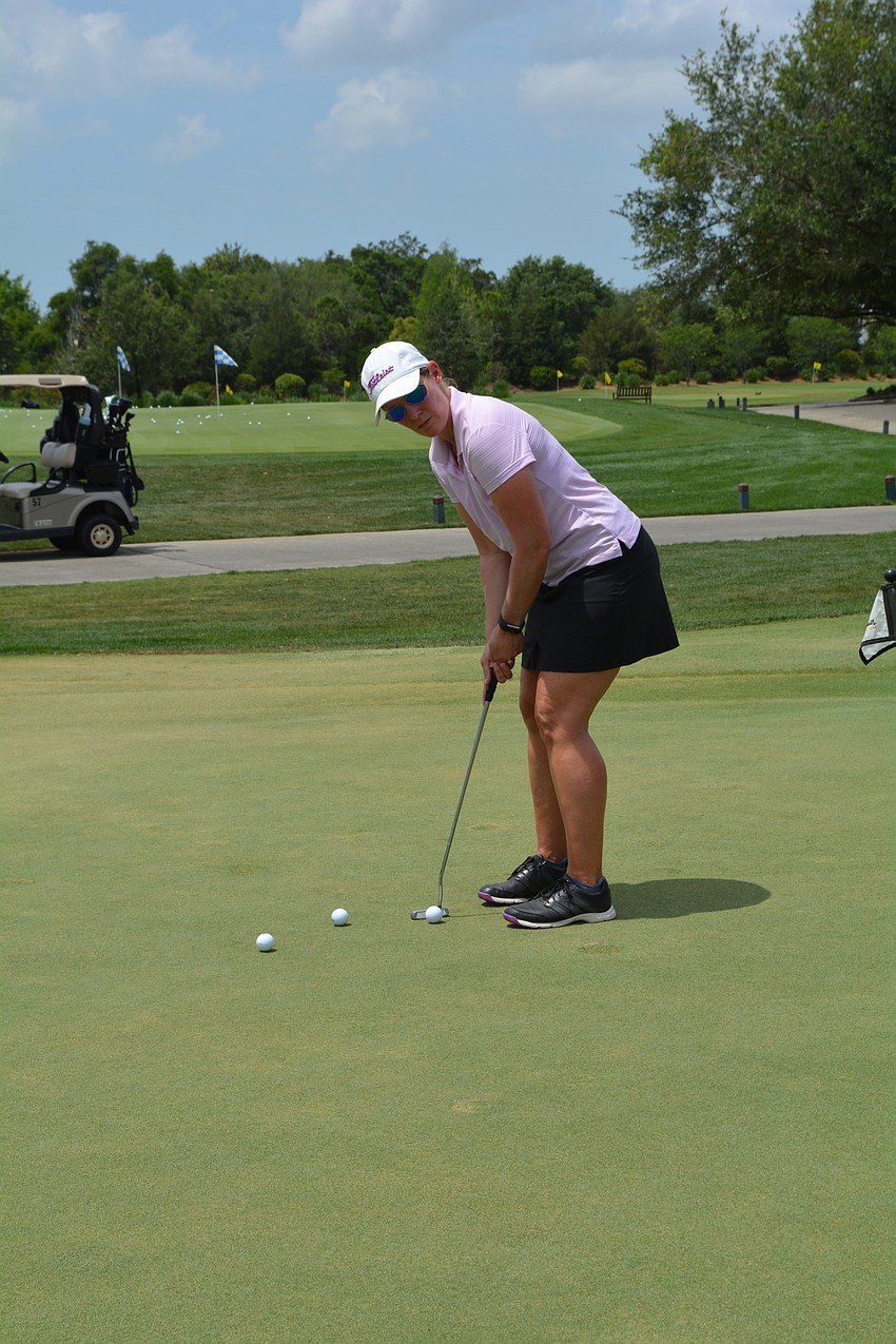 Shelly McAvoy, of Cooper Creek Dental, practices putting before the start of the tournament.