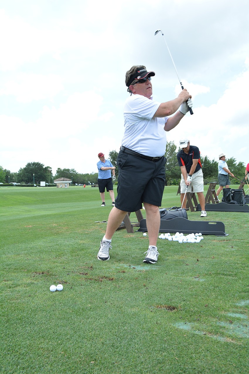 Bruce Loepke, of Willis Smith Construction, perfects his swing on the driving range.